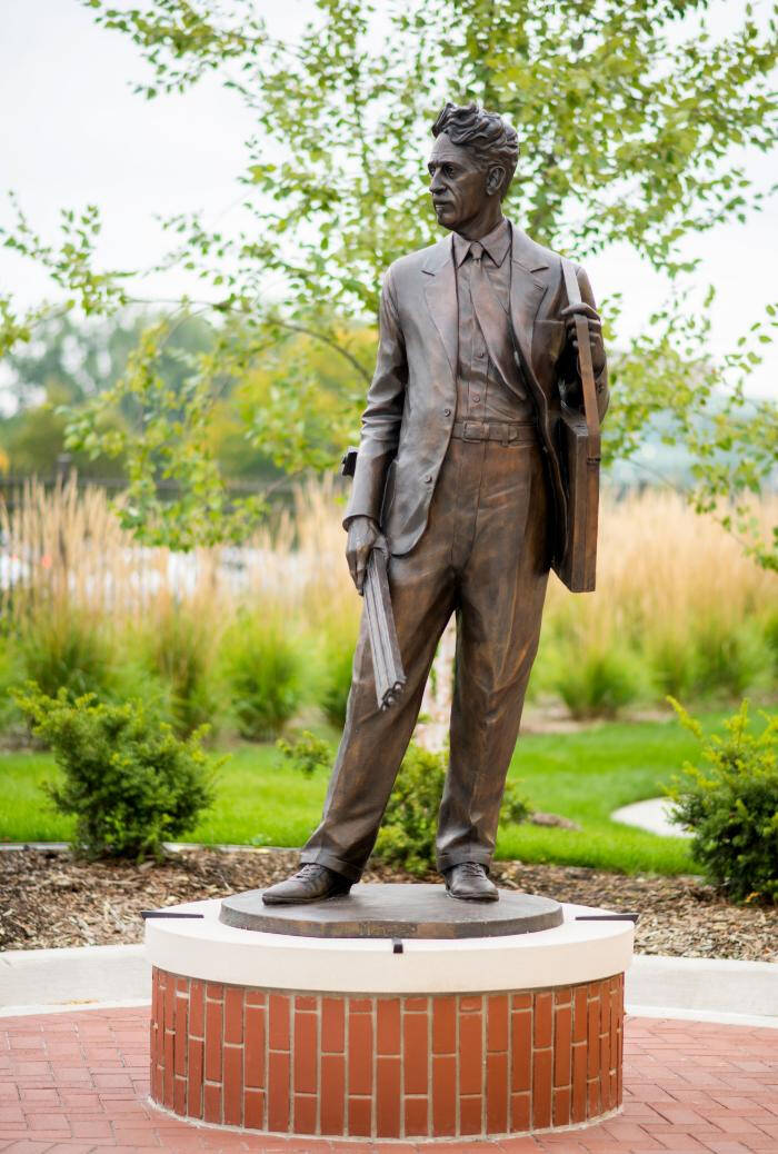 Photograph of an outdoor bronze sculpture of a man standing